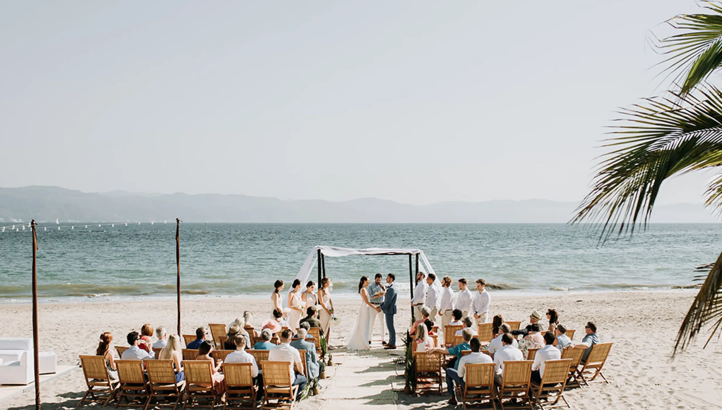 Beachfront wedding ceremony with a white canopy at Velas Vallarta, Puerto Vallarta