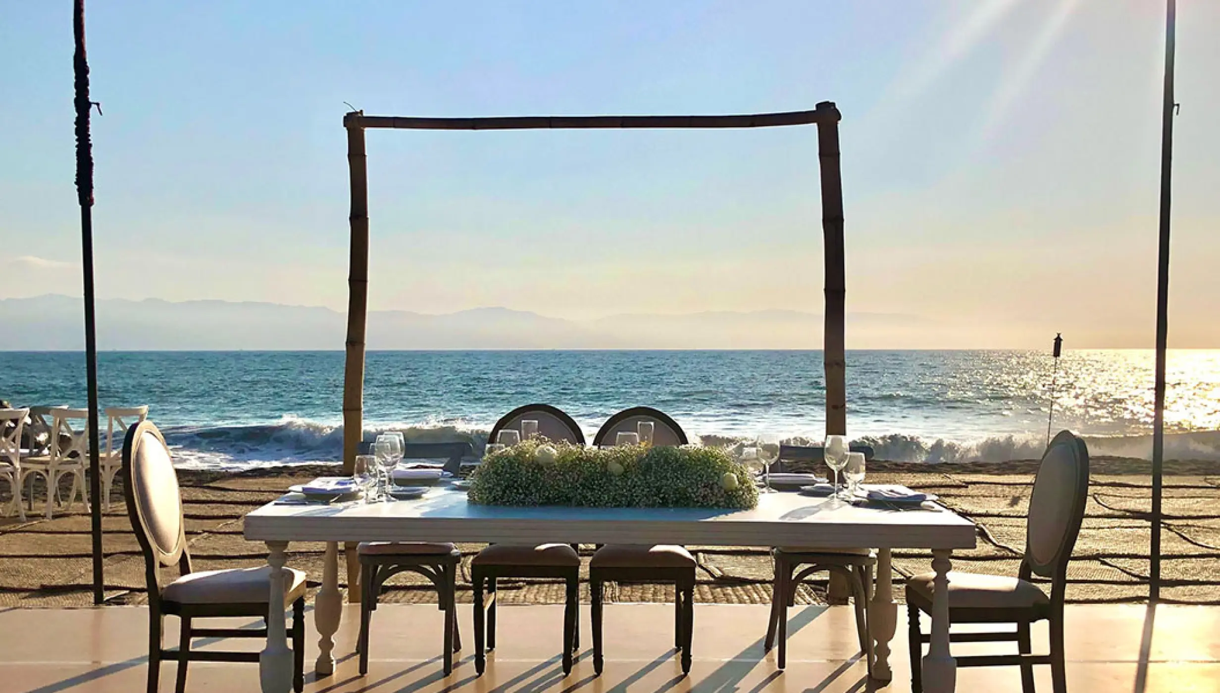 Beachfront wedding reception table with white floral centerpiece at Velas Vallarta, Puerto Vallarta
