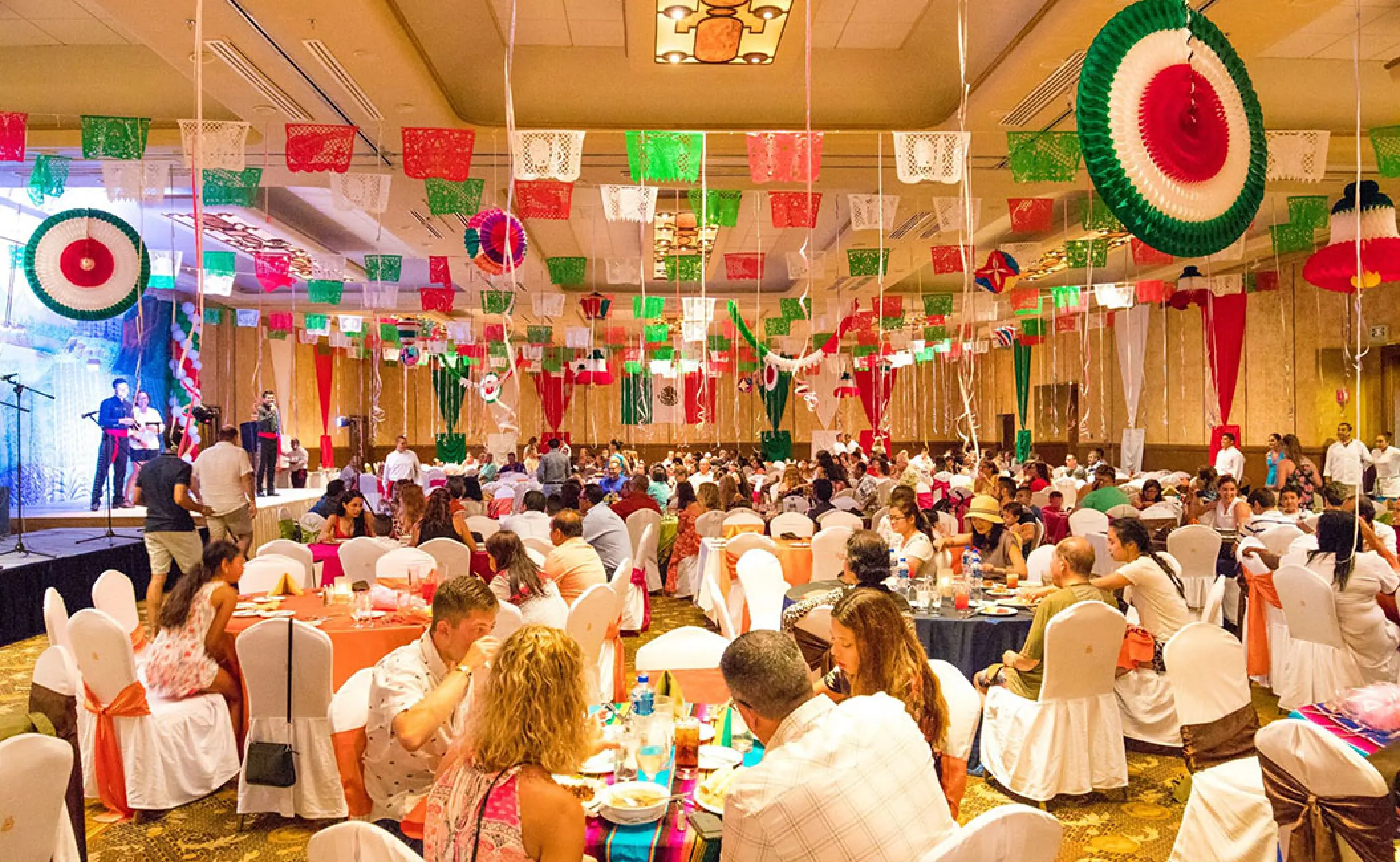 Wedding reception in the ballroom at Velas Vallarta, Puerto Vallarta decorated with colorful Mexican fiesta banners