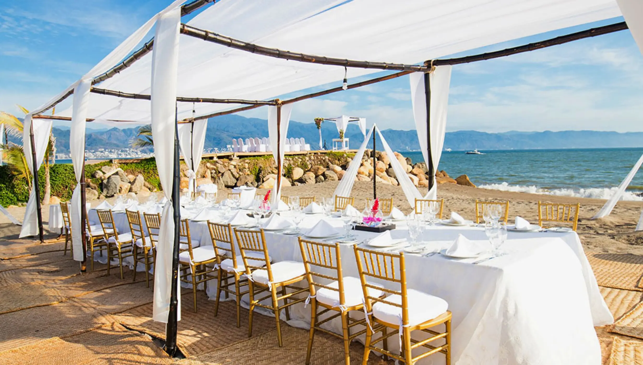 Long table wedding reception under a white canopy at Velas Vallarta, Puerto Vallarta