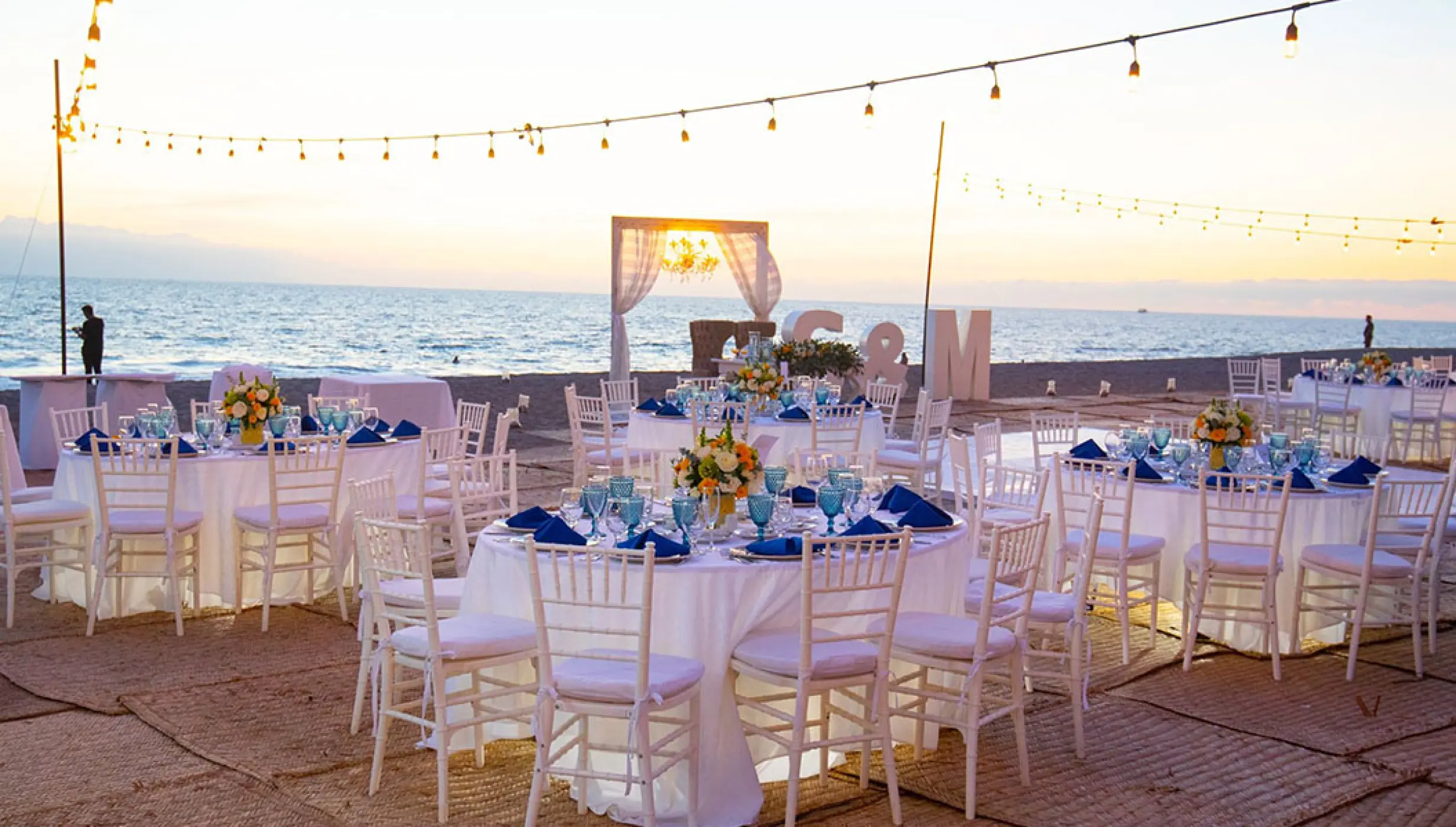 Beachfront wedding reception with string lights and blue décor at Velas Vallarta, Puerto Vallarta