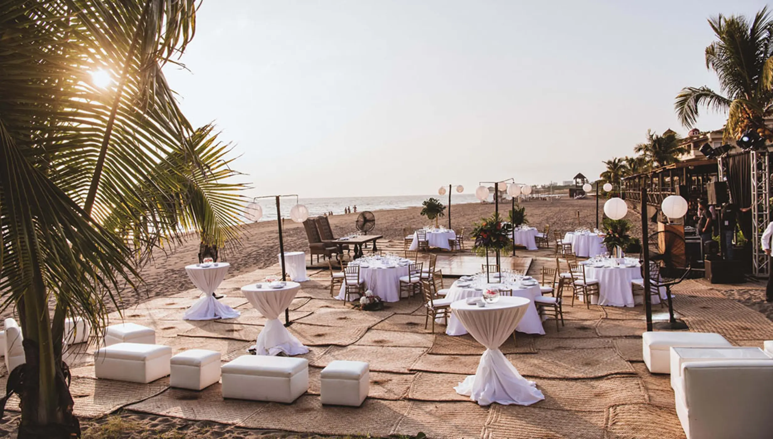 Beachfront wedding reception setup with white lounge seating and round tables at Velas Vallarta, Puerto Vallarta