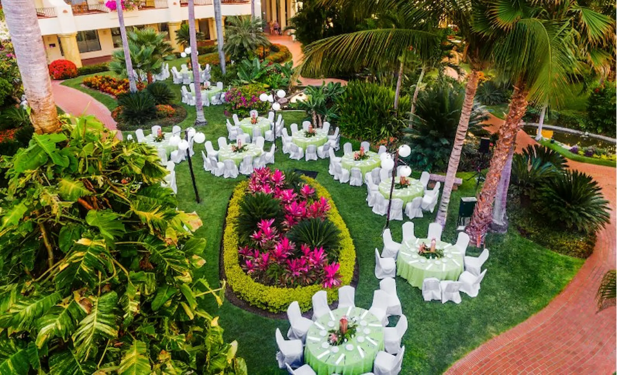 Garden wedding reception at Velas Vallarta with round tables set on a lush green lawn in Puerto Vallarta