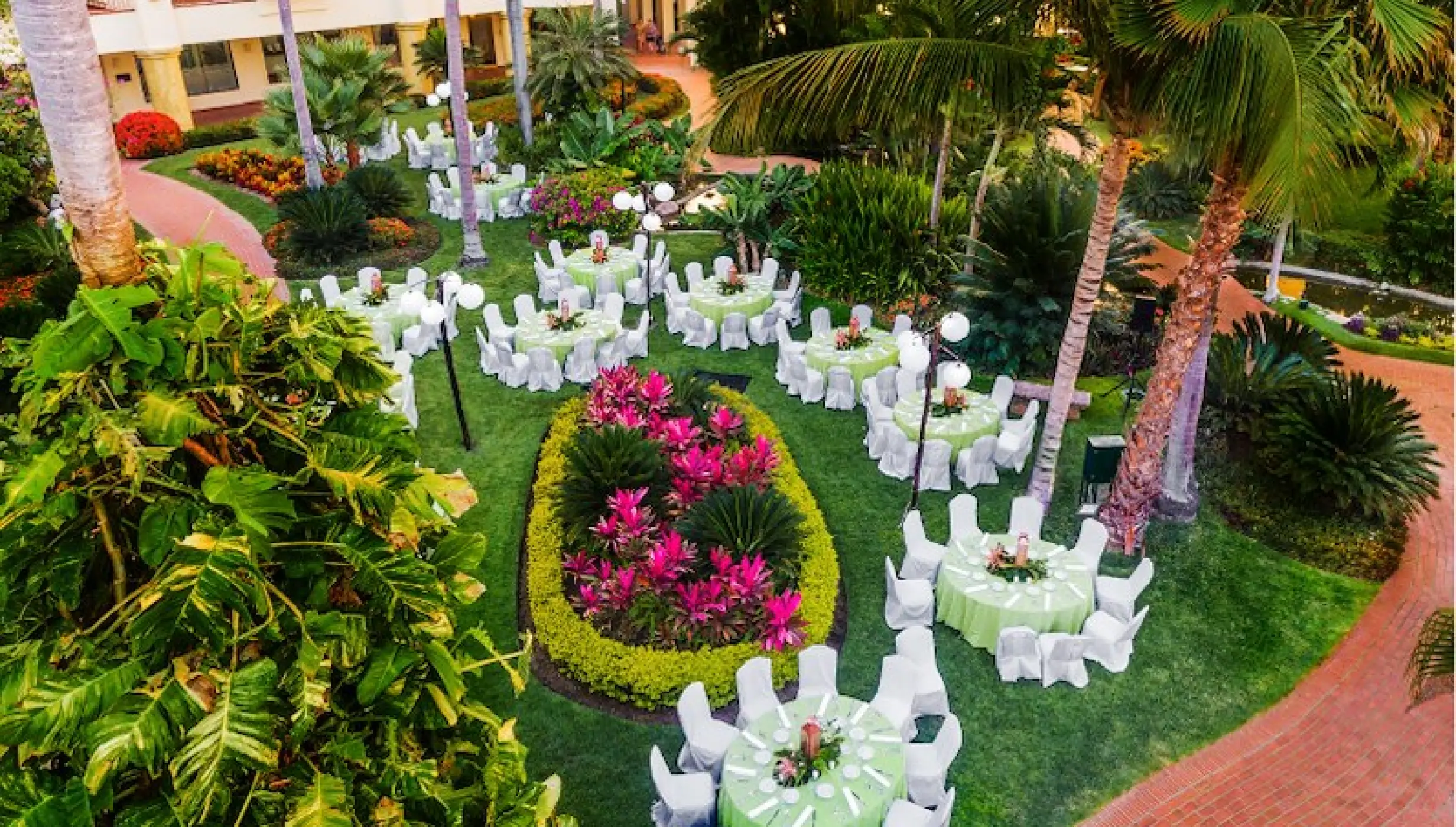 Garden wedding reception at Velas Vallarta with round tables set on a lush green lawn in Puerto Vallarta