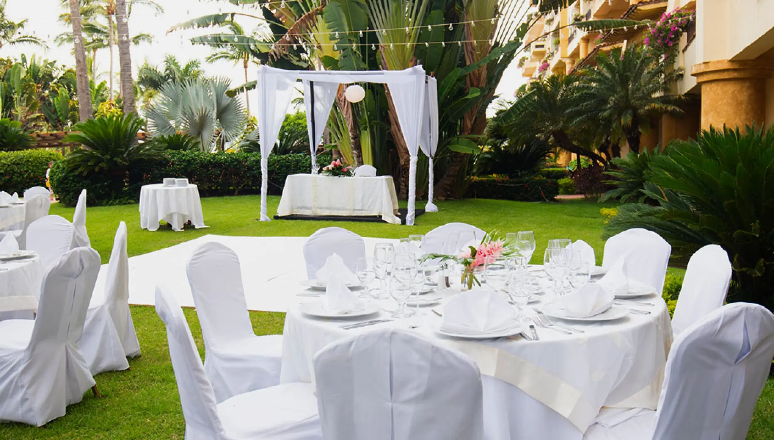 Garden wedding reception setup with white linens and draped gazebo at Velas Vallarta, Puerto Vallarta