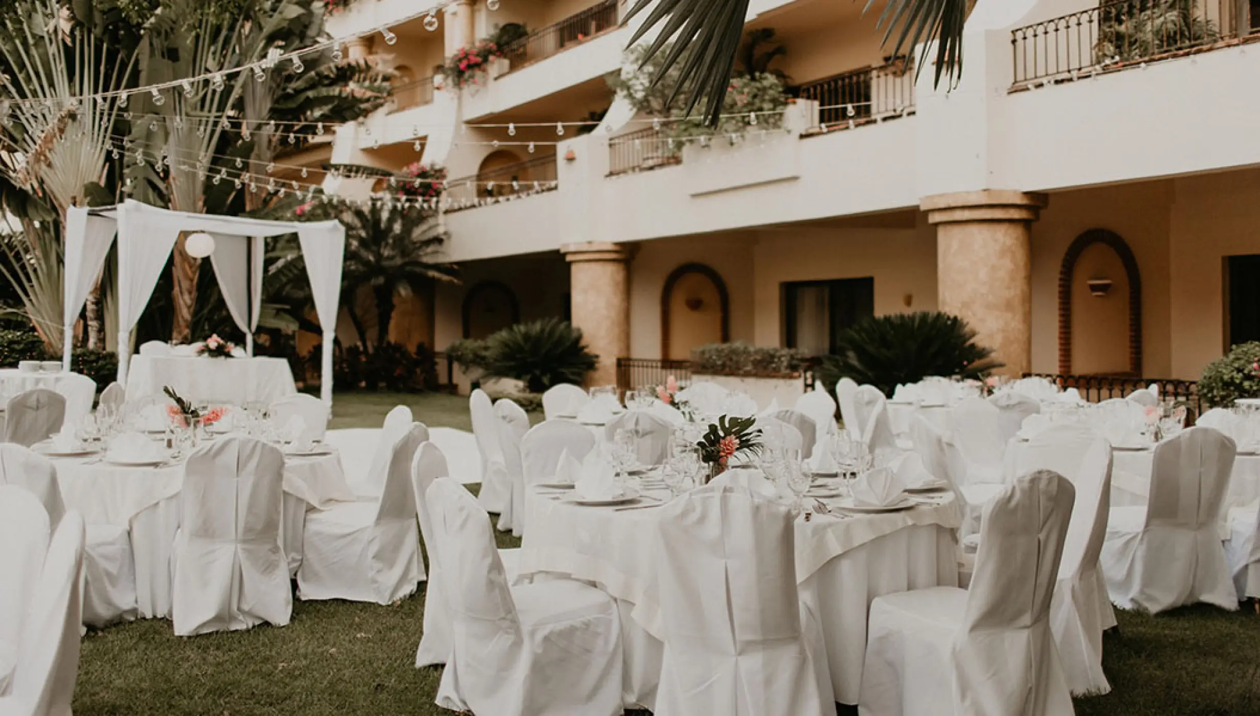 Garden wedding reception with white linens and string lights at Velas Vallarta, Puerto Vallarta