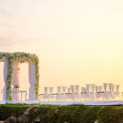 Pier wedding ceremony setup with flower-covered gazebo and white chairs at Velas Vallarta, Puerto Vallarta