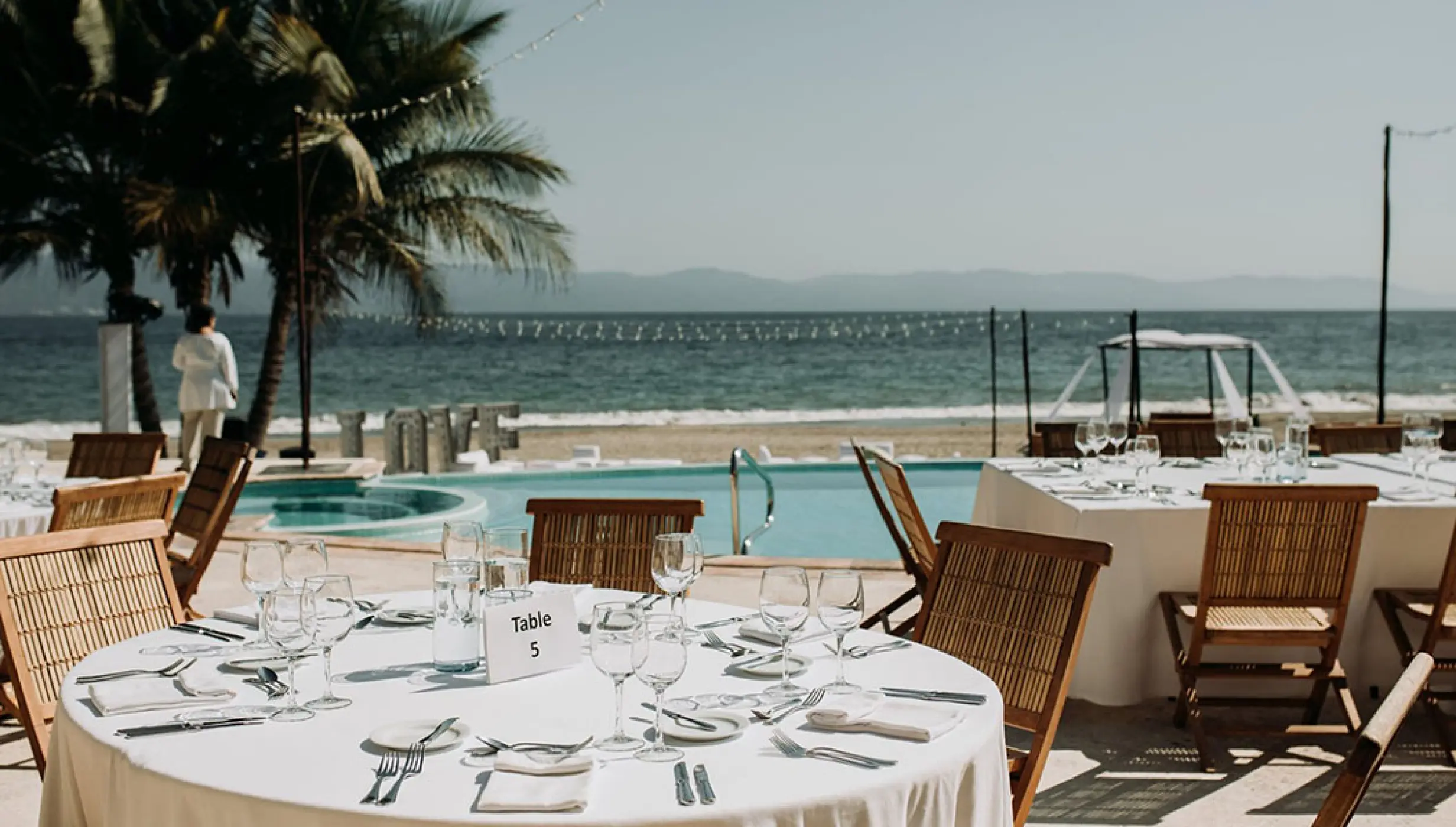 Outdoor wedding reception table setup on a terrace by the pool at Velas Vallarta, Puerto Vallarta