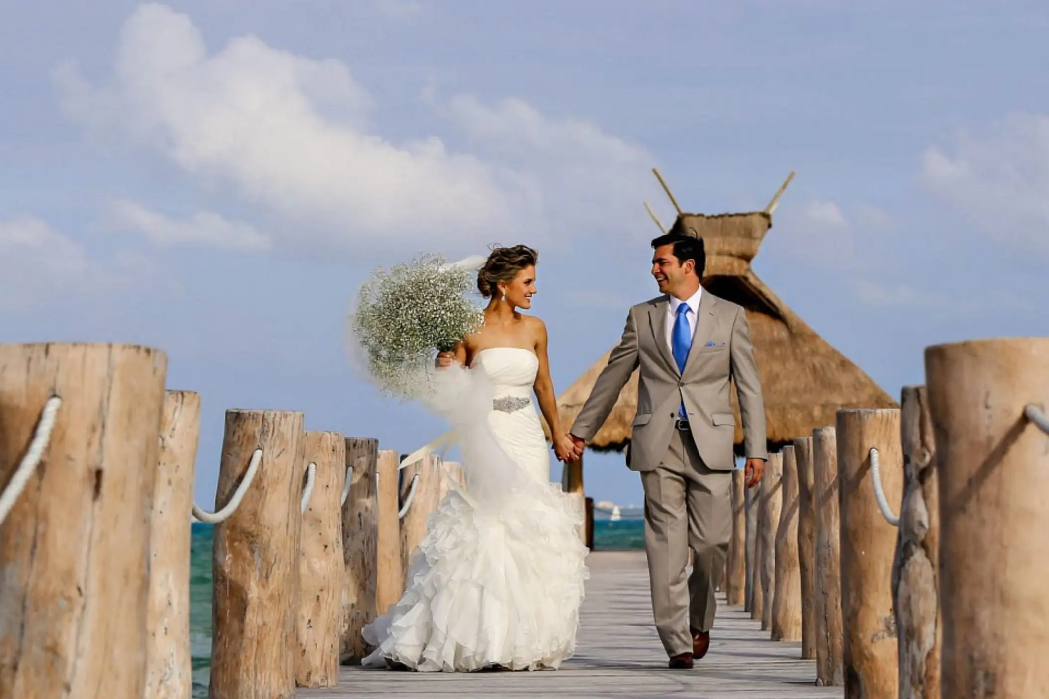 The bride and groom walking on the pier at Villa del Palmar, Cancun