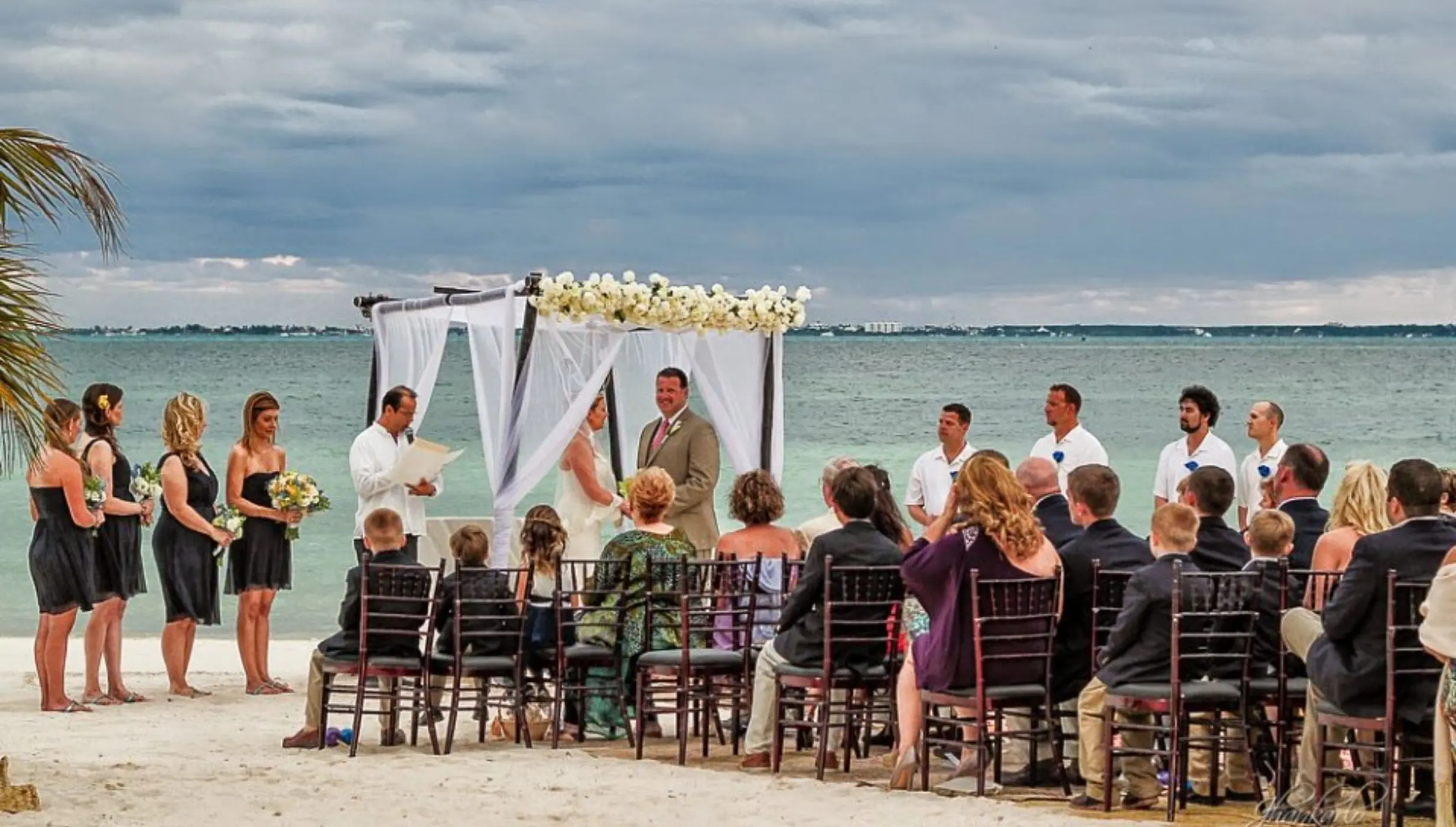 bride and groom and guests at the capricos beach venue ceremony at Villa del Palmar Cancun