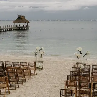 Beachfront wedding ceremony at Villa del Palmar Cancun with a long wooden pier in the background