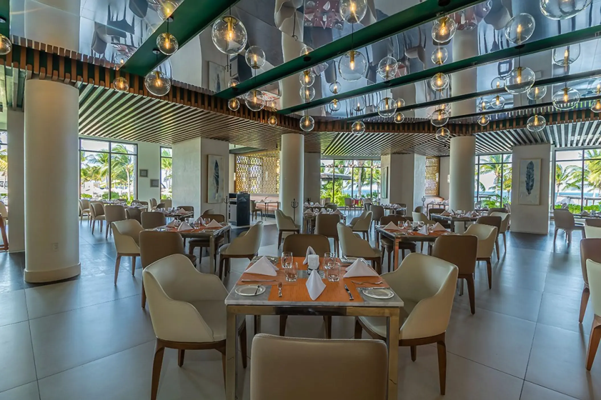 Davino restaurant interior with globe lighting and modern seating at Villa del Palmar, Cancun