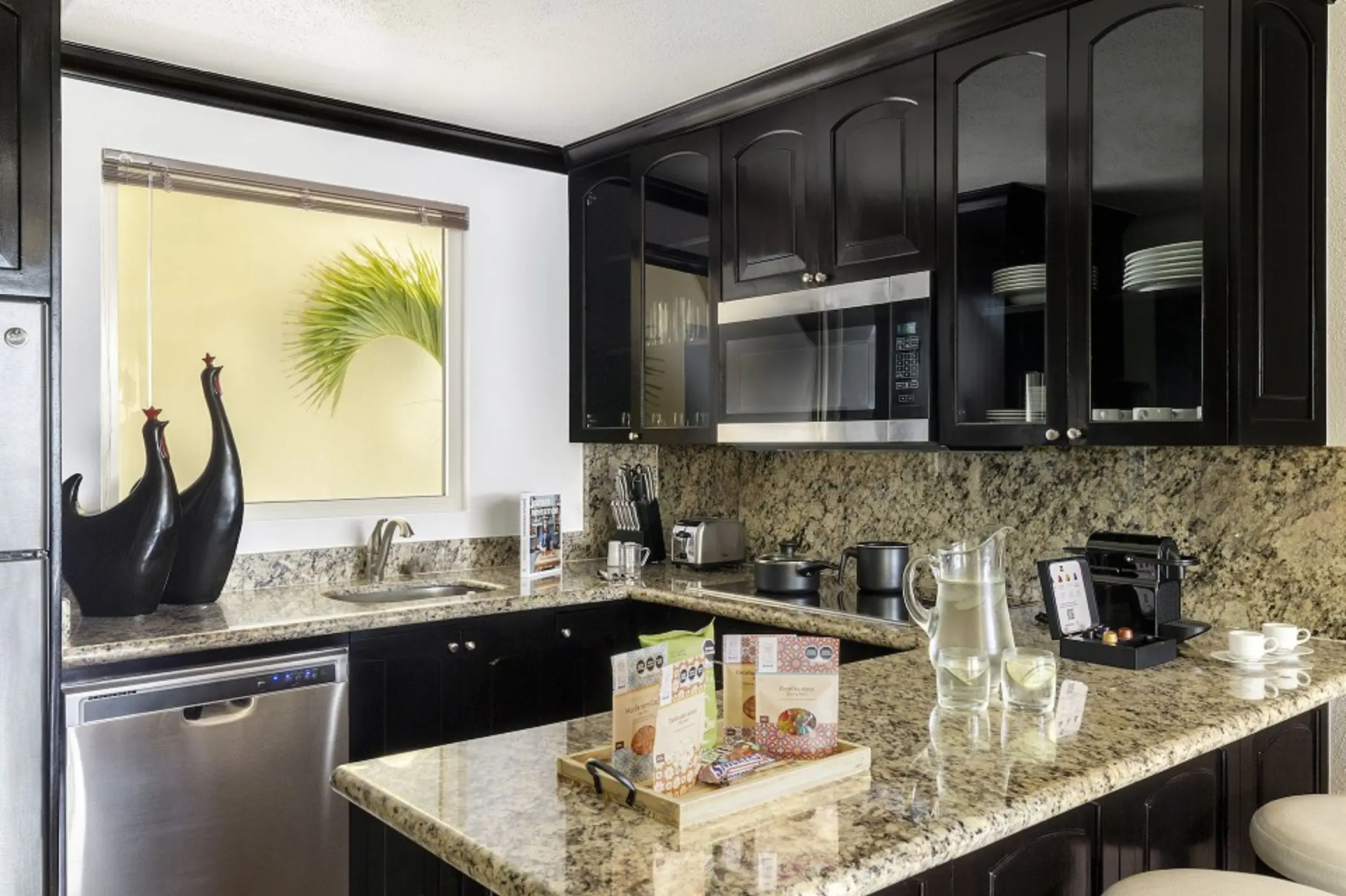 Modern suite kitchen with granite countertops and dark wood cabinetry at Villa del Palmar Cancun