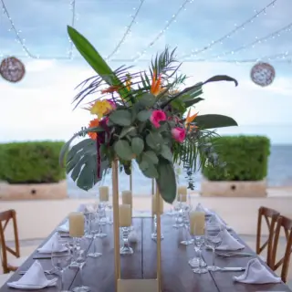 Tropical floral centerpiece on an outdoor reception table at Villa del Palmar Cancun