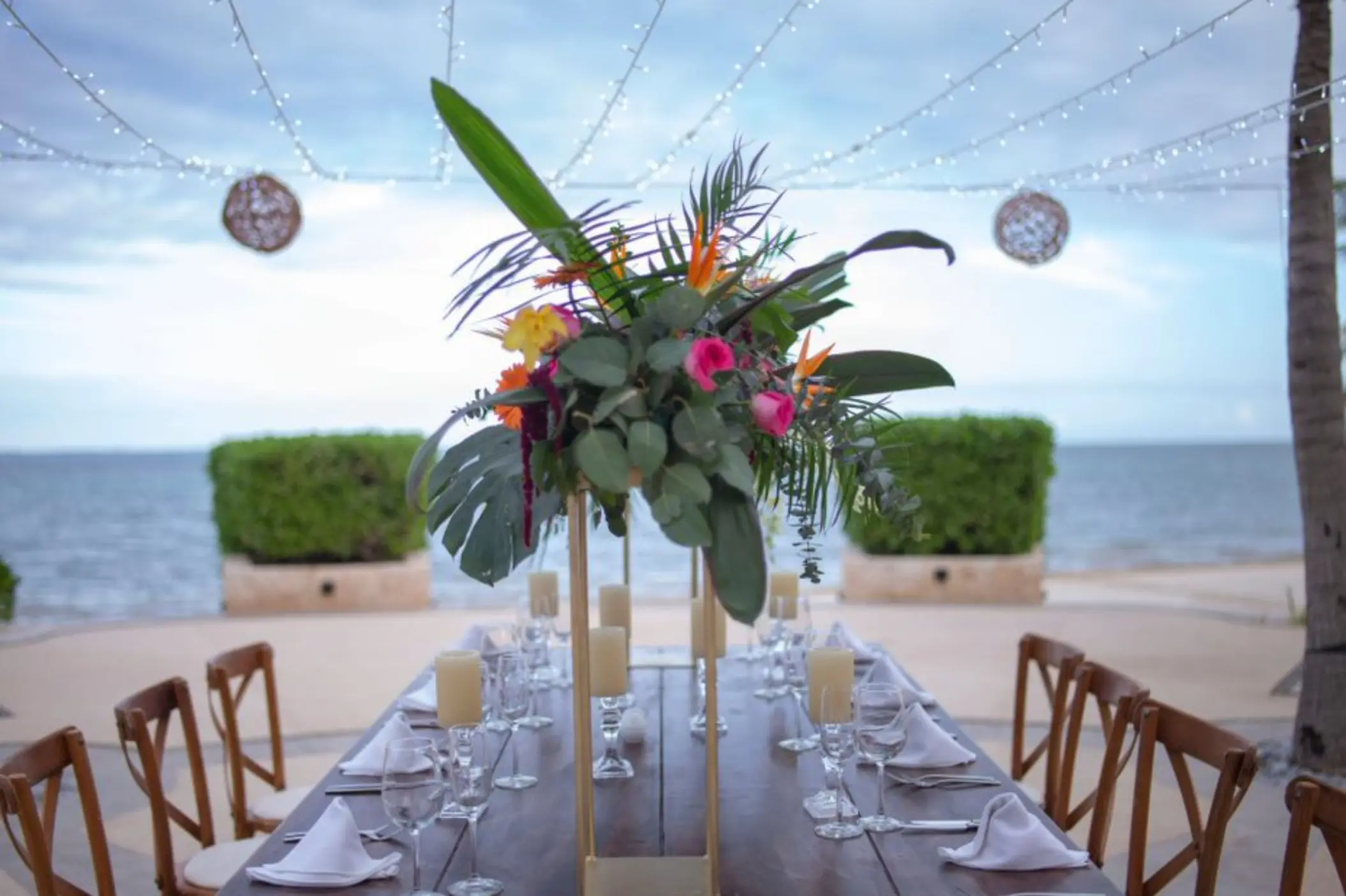 Tropical floral centerpiece on an outdoor reception table at Villa del Palmar Cancun