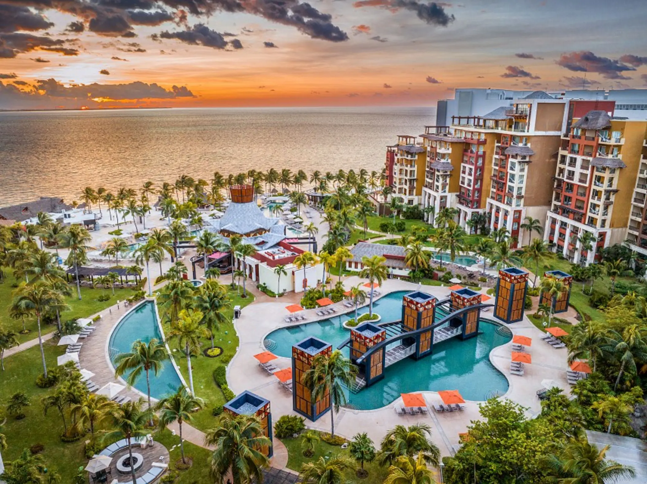 Aerial view of Villa del Palmar Cancun swimming pools and beachfront at sunset, Cancun