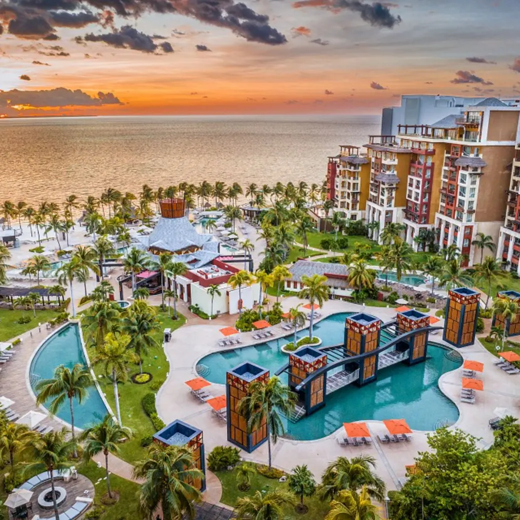 Aerial view of Villa del Palmar Cancun swimming pools and beachfront at sunset, Cancun