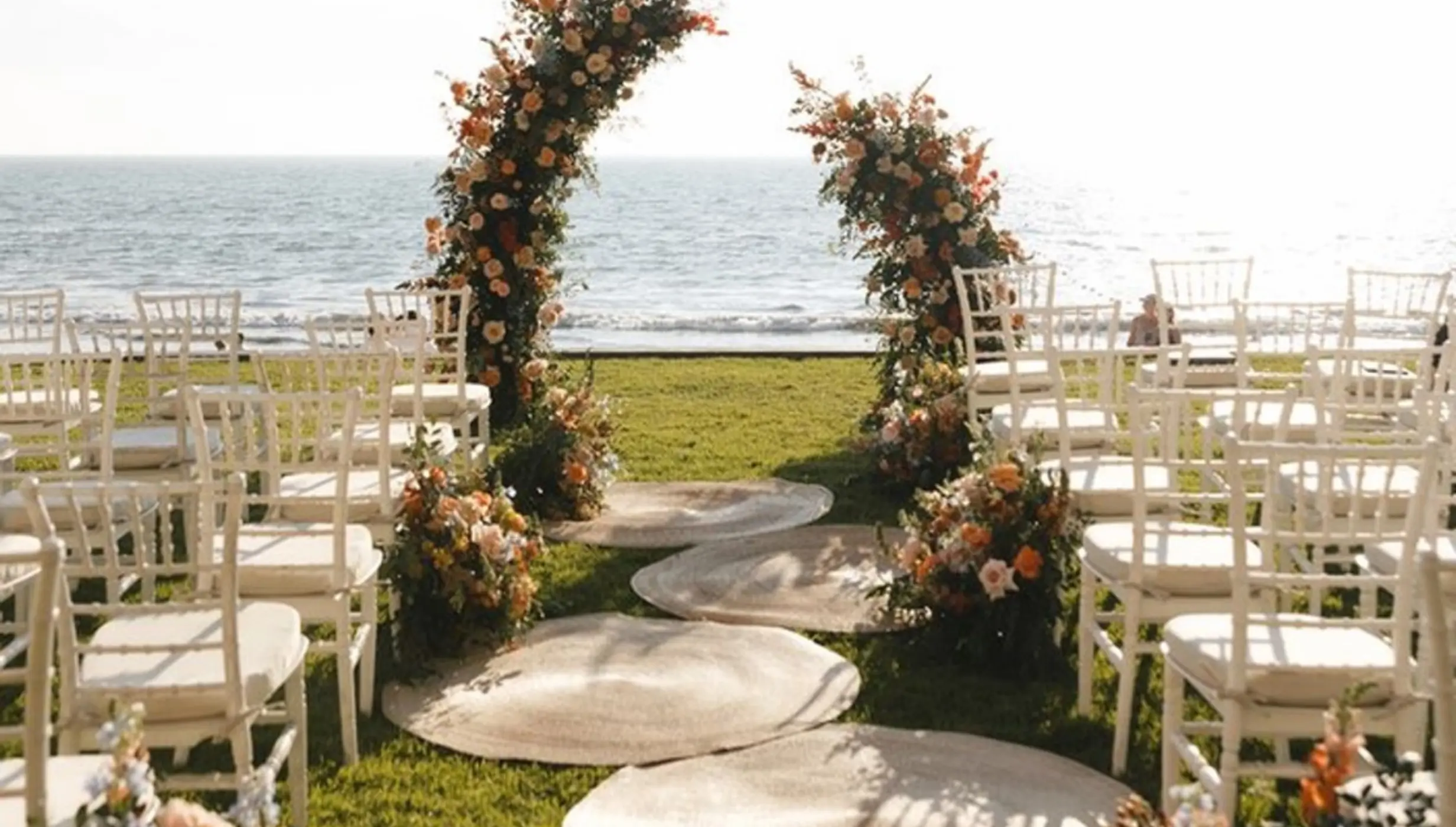 Garden wedding ceremony with floral arch and white chairs at Villa La Estancia, Puerto Vallarta
