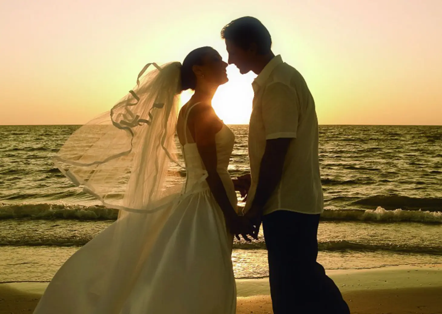 Silhouette of a couple holding hands during a sunset beach wedding at Villa La Estancia Riviera Nayarit