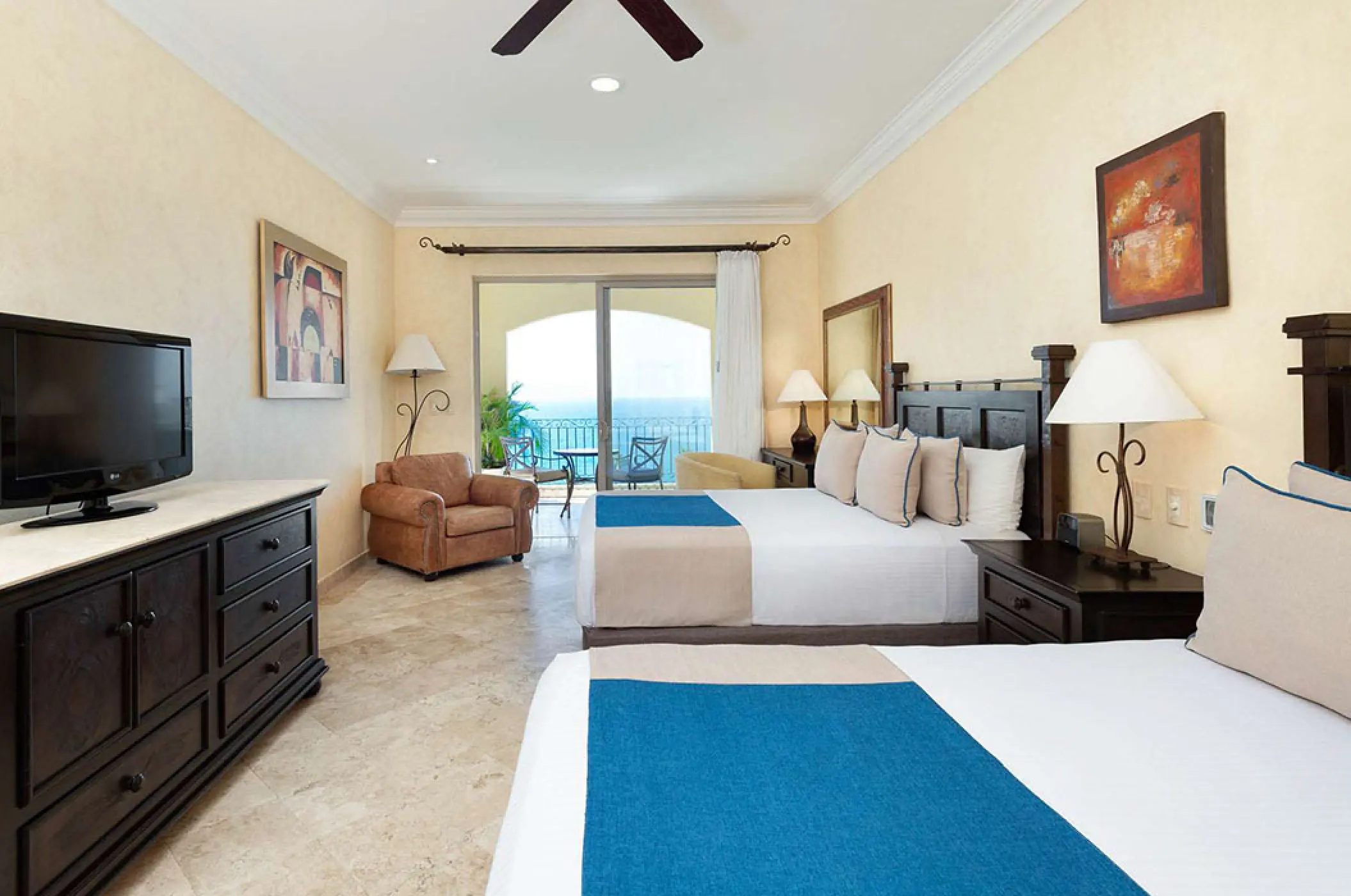 Two-bedroom suite with dark wood furniture and ocean-view balcony at Villa La Estancia Riviera Nayarit, Puerto Vallarta