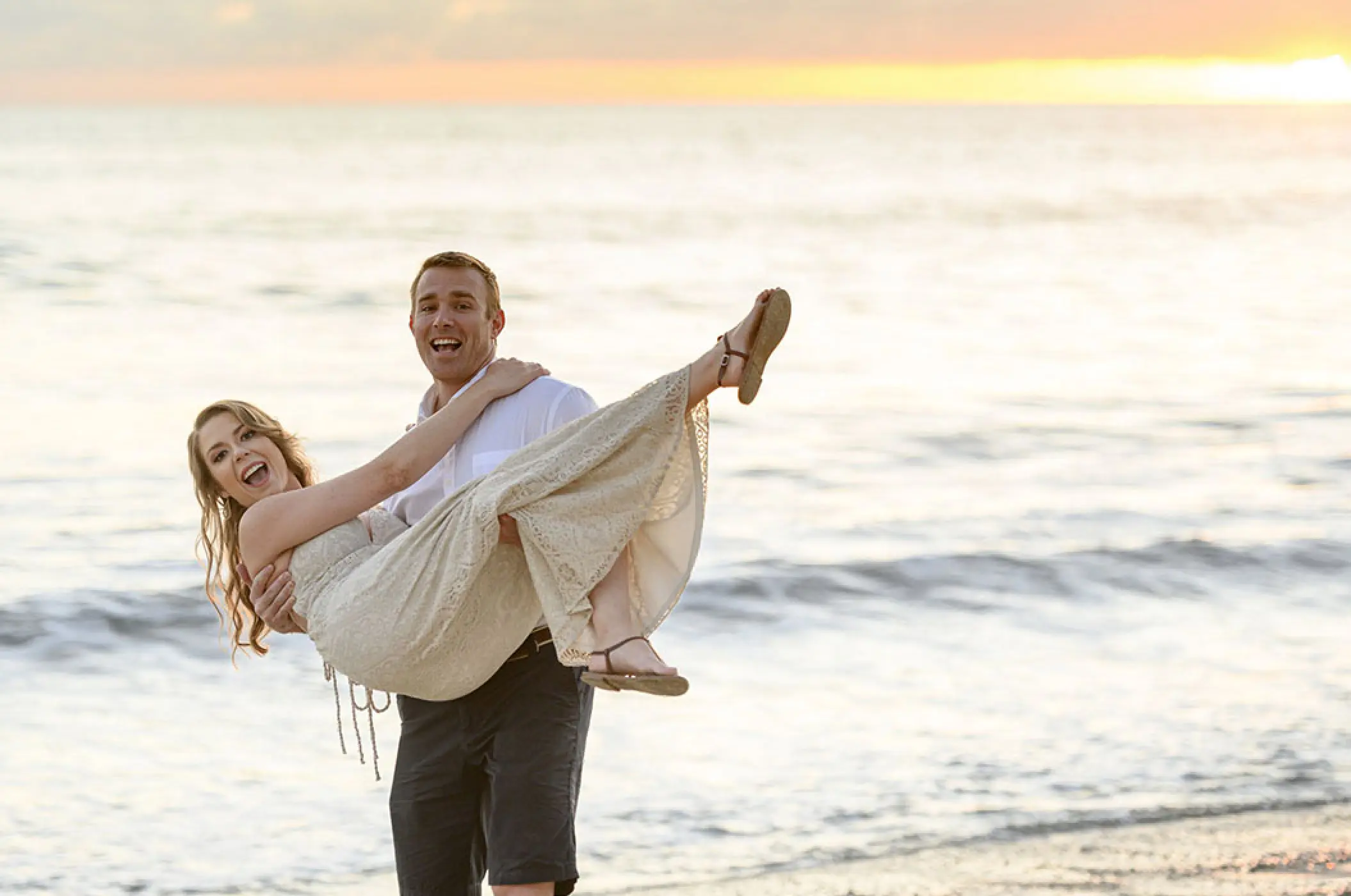 Groom carrying his bride on the beach at sunset, Villa La Estancia Riviera Nayarit