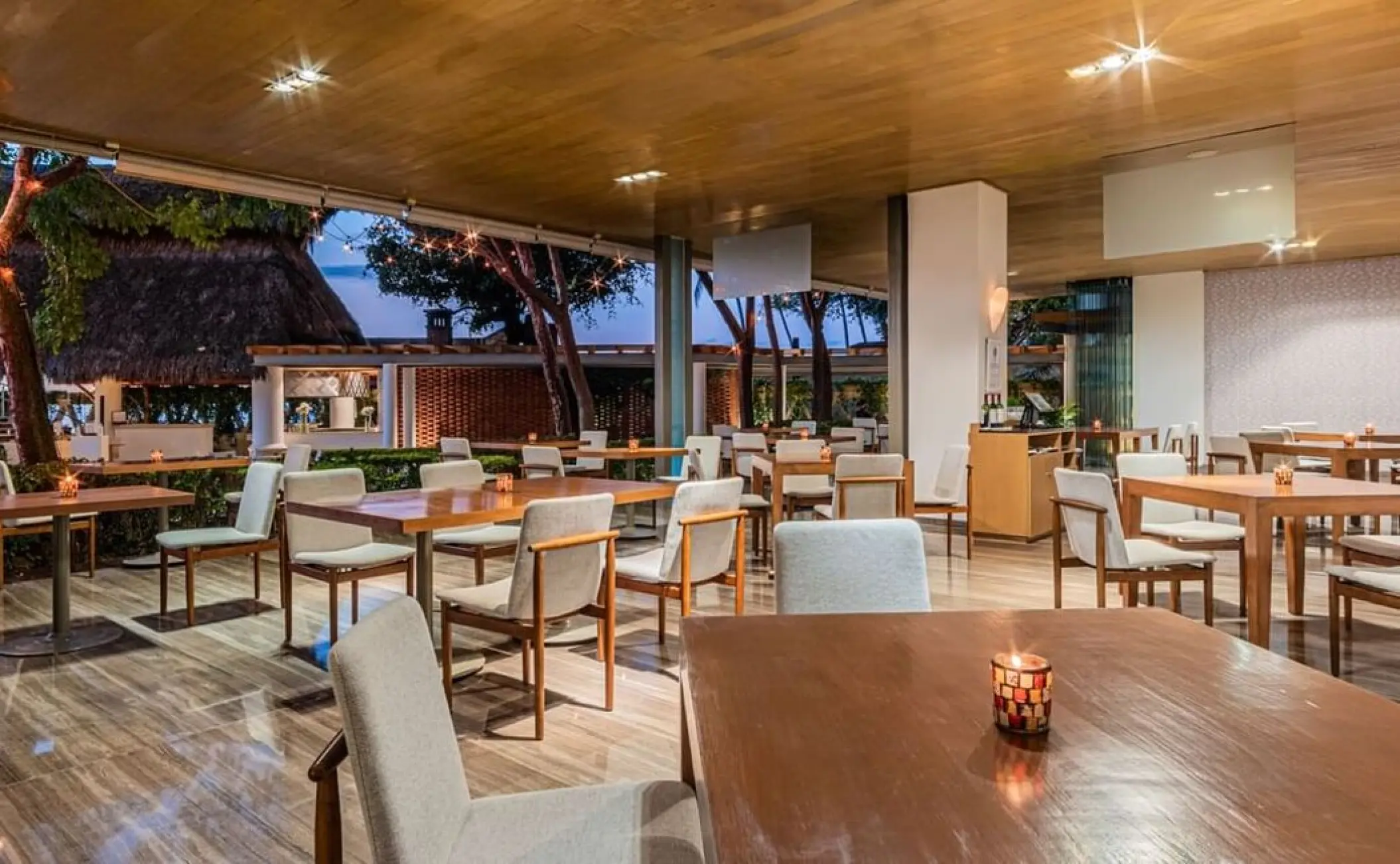 La Corona open-air restaurant with wooden tables and chairs at Villa Premiere Boutique Hotel, Puerto Vallarta