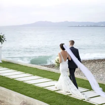 Bride and groom walking along the oceanfront jetty at Villa Premiere Boutique Hotel, Puerto Vallarta