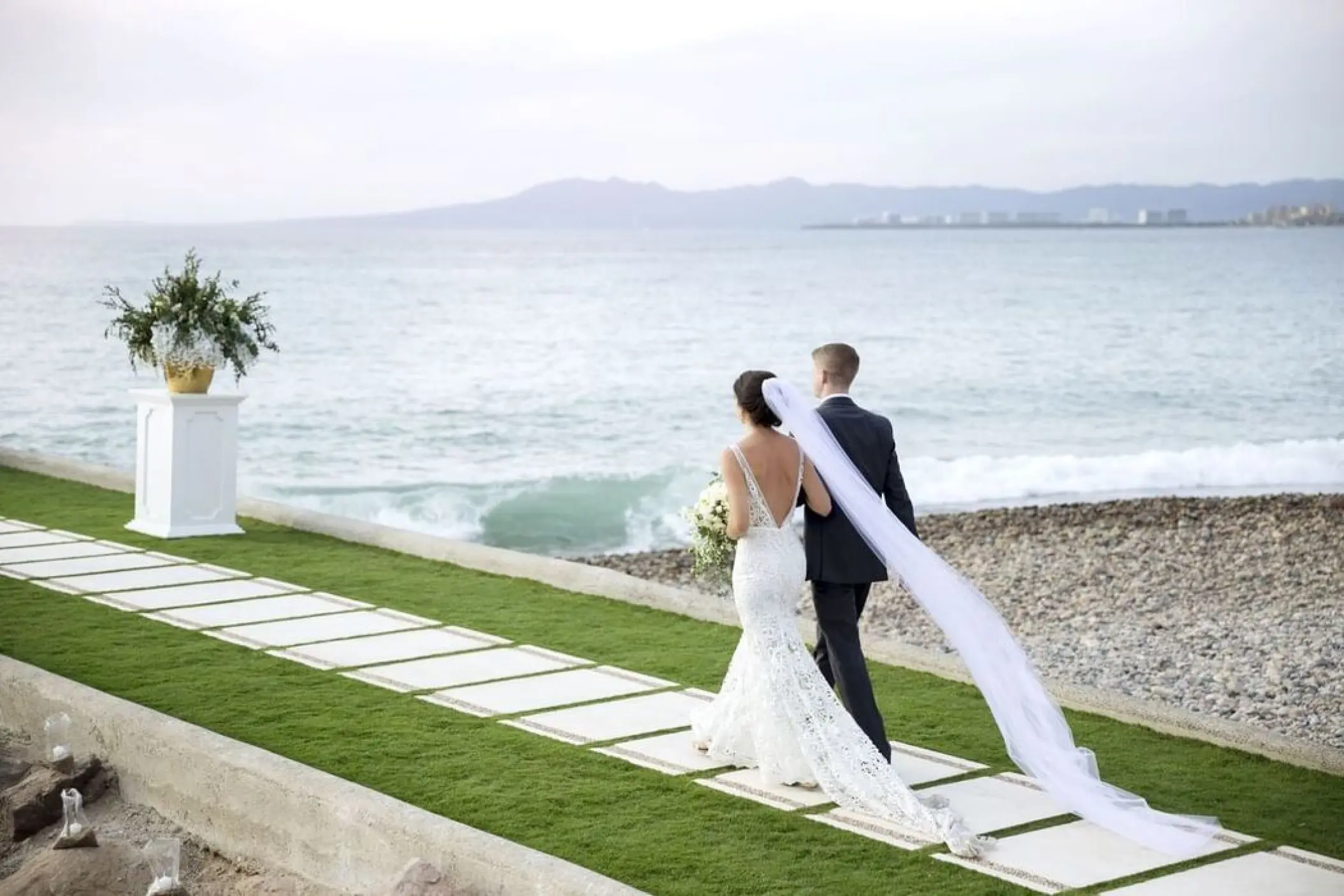 Bride and groom walking along the oceanfront jetty at Villa Premiere Boutique Hotel, Puerto Vallarta