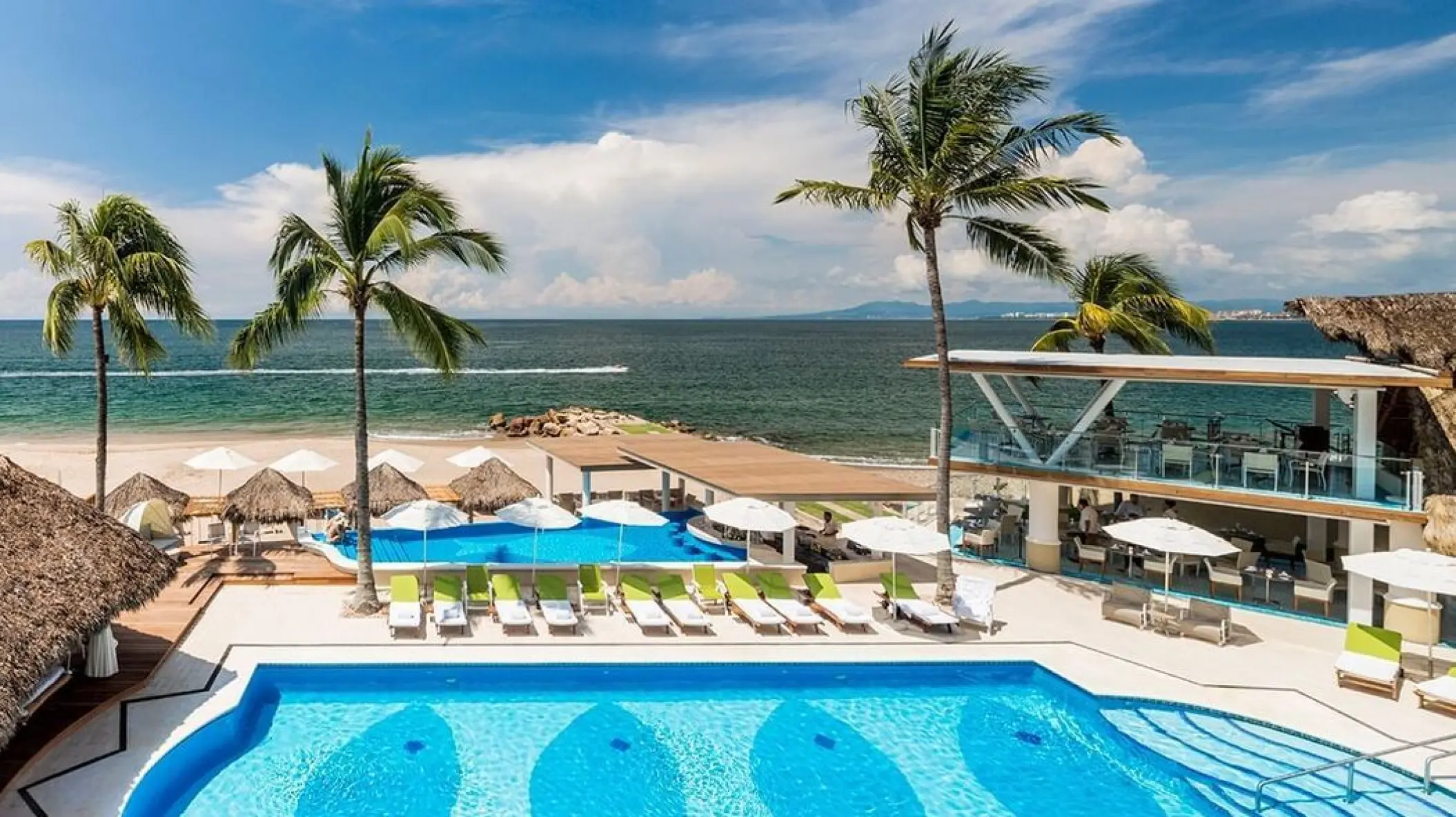 Main pool and beach deck with palm trees at Villa Premiere Boutique Hotel, Puerto Vallarta