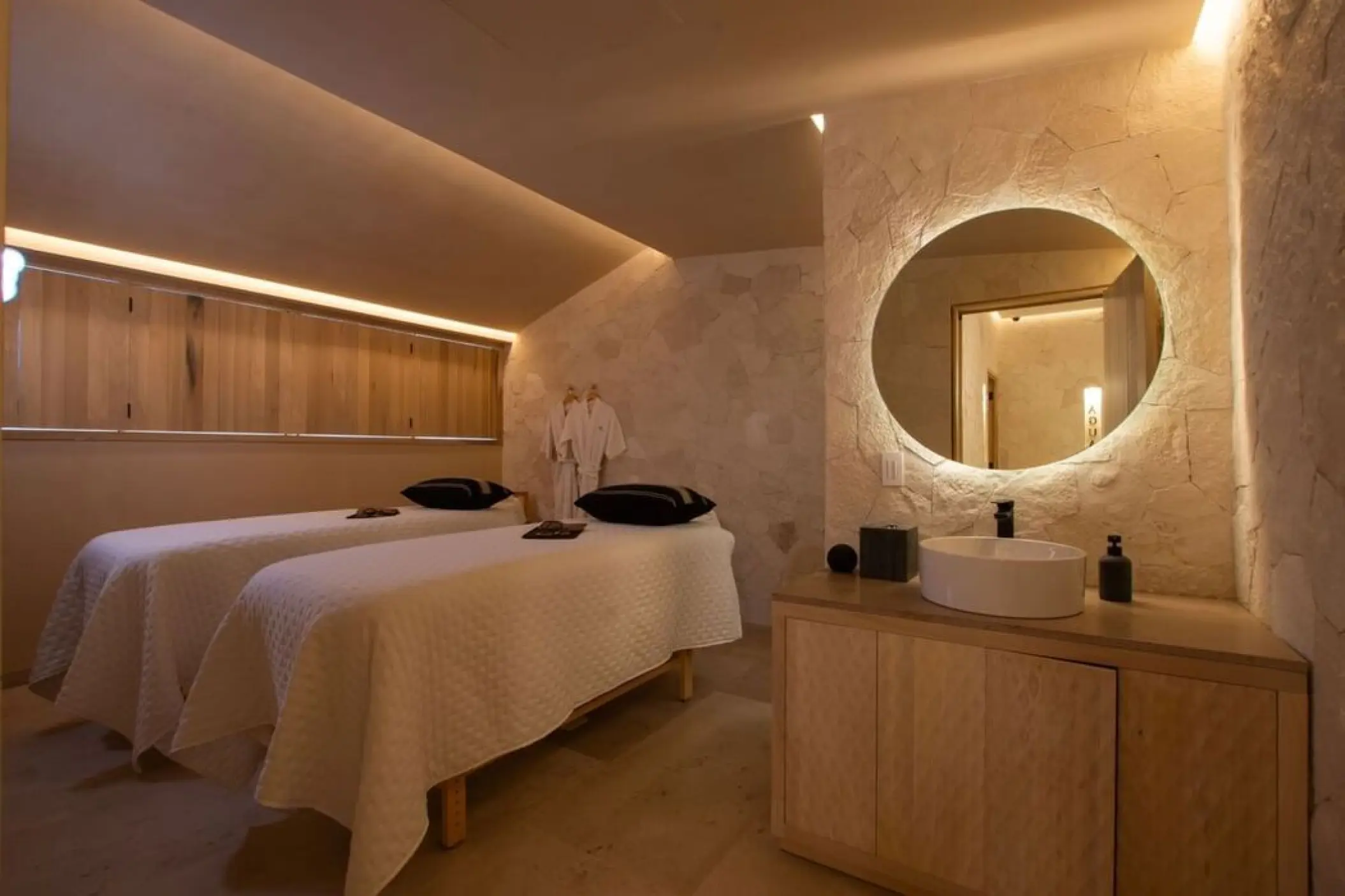 Spa treatment room with two massage beds and stone walls at Villa Premiere Boutique Hotel, Puerto Vallarta