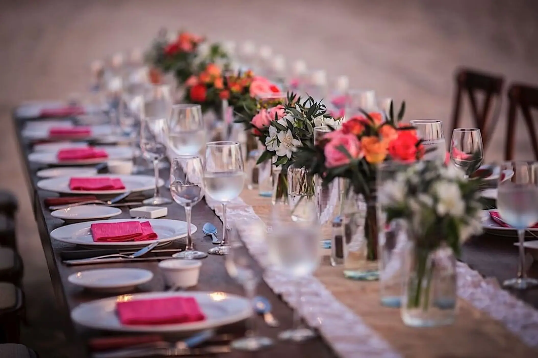 Wedding reception table with floral centerpieces and pink napkins at Villa Premiere Boutique Hotel, Puerto Vallarta