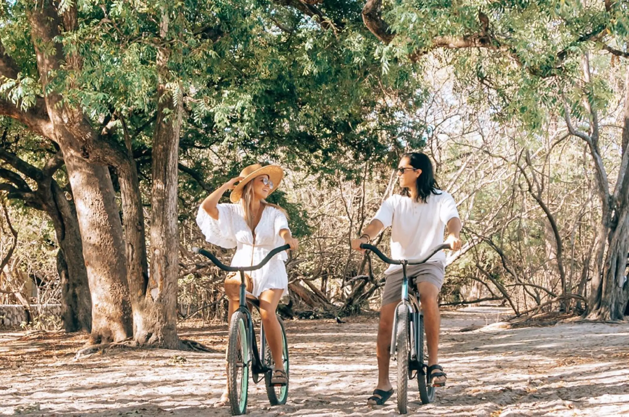 Couple cycling along a wooded path at Westin Reserva Conchal, Liberia
