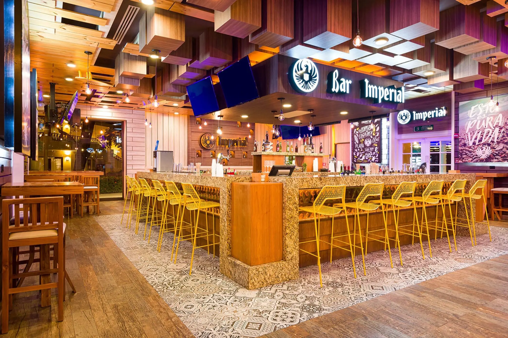 Bar Imperial with yellow barstools and wood-paneled ceiling at Westin Reserva Conchal, Liberia