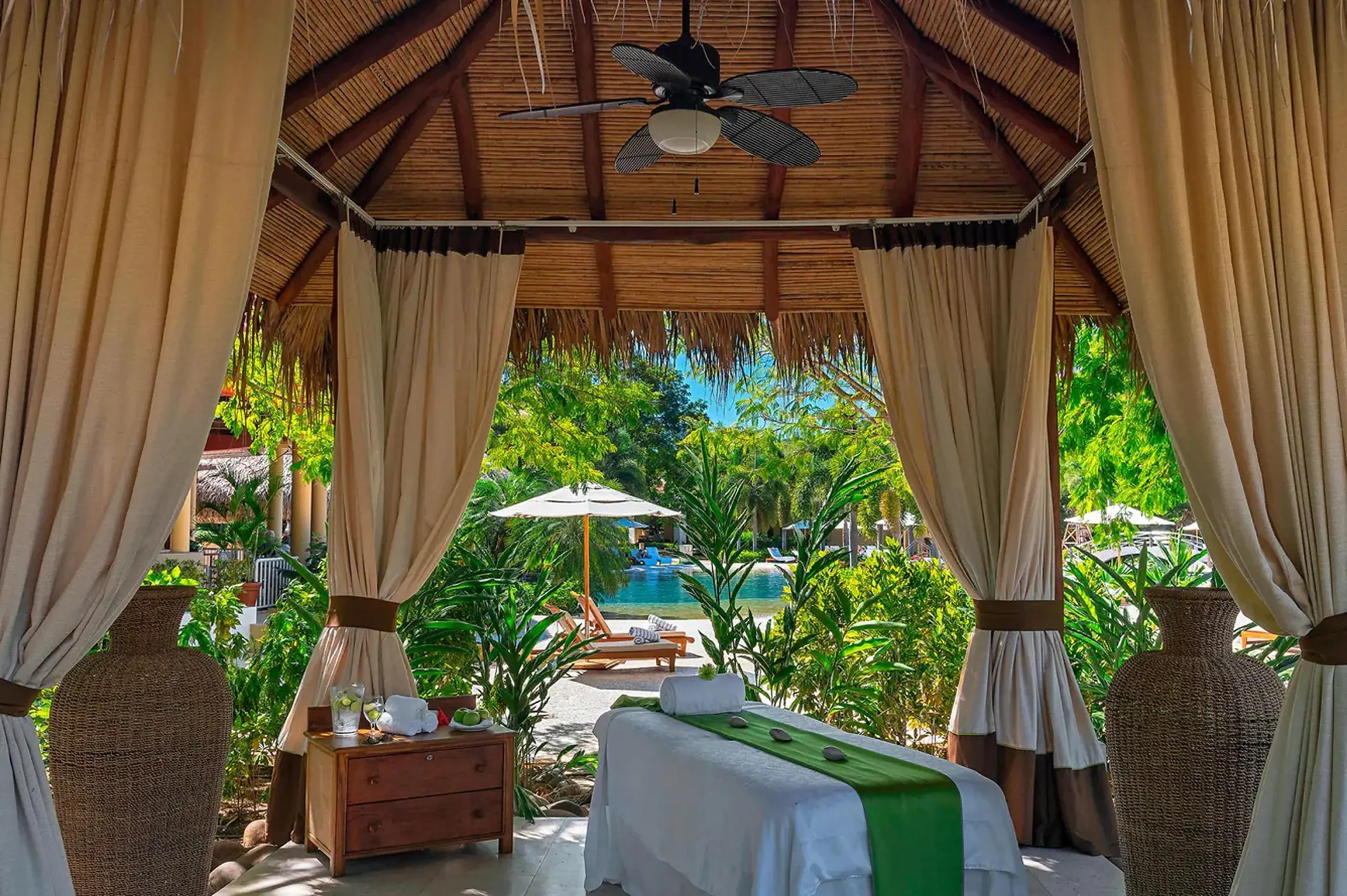 Outdoor spa treatment table under a thatched palapa at Westin Reserva Conchal, Liberia