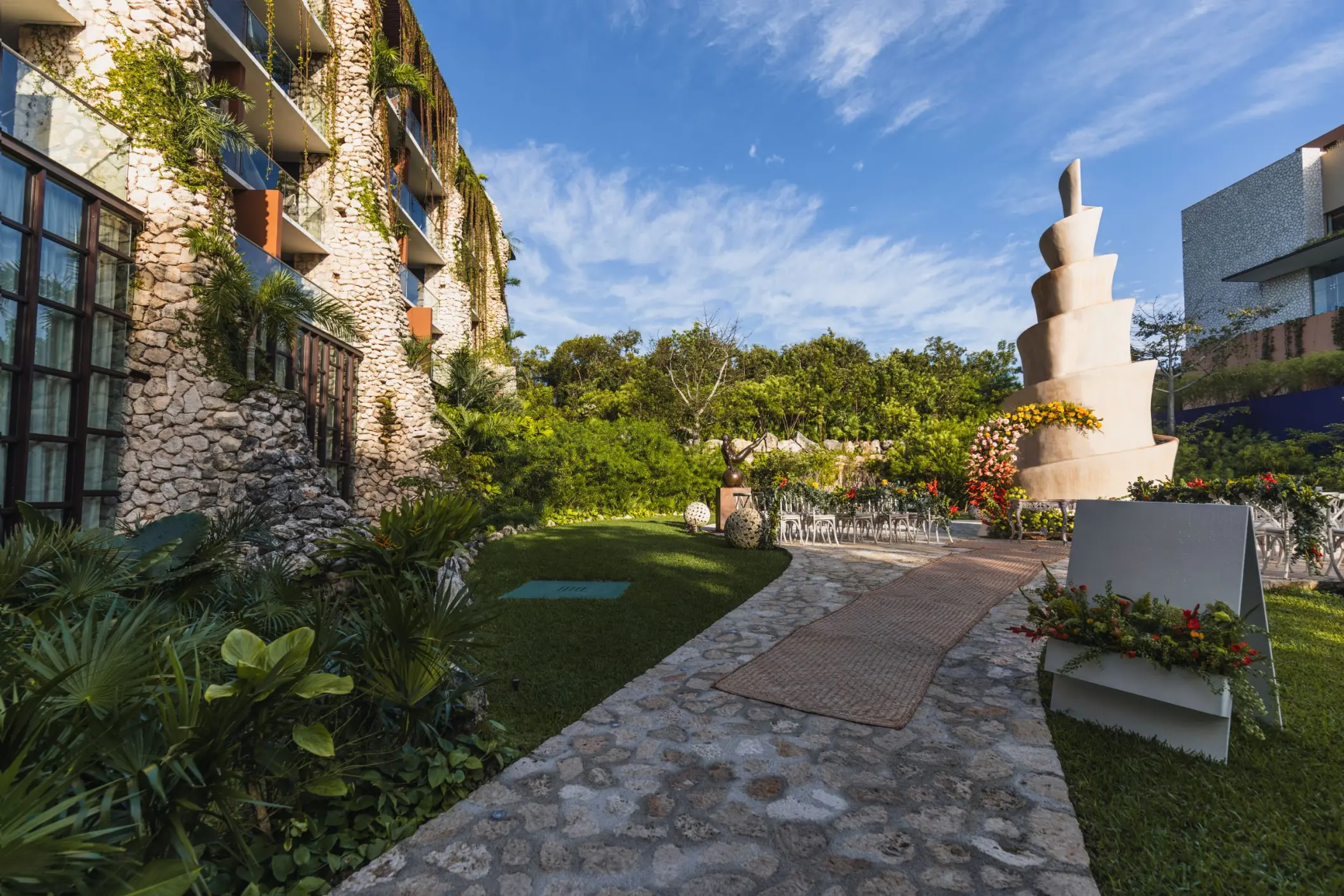 Caracol terrace wedding ceremony setup with spiral stone sculpture at Hotel Xcaret Arte, Riviera Maya