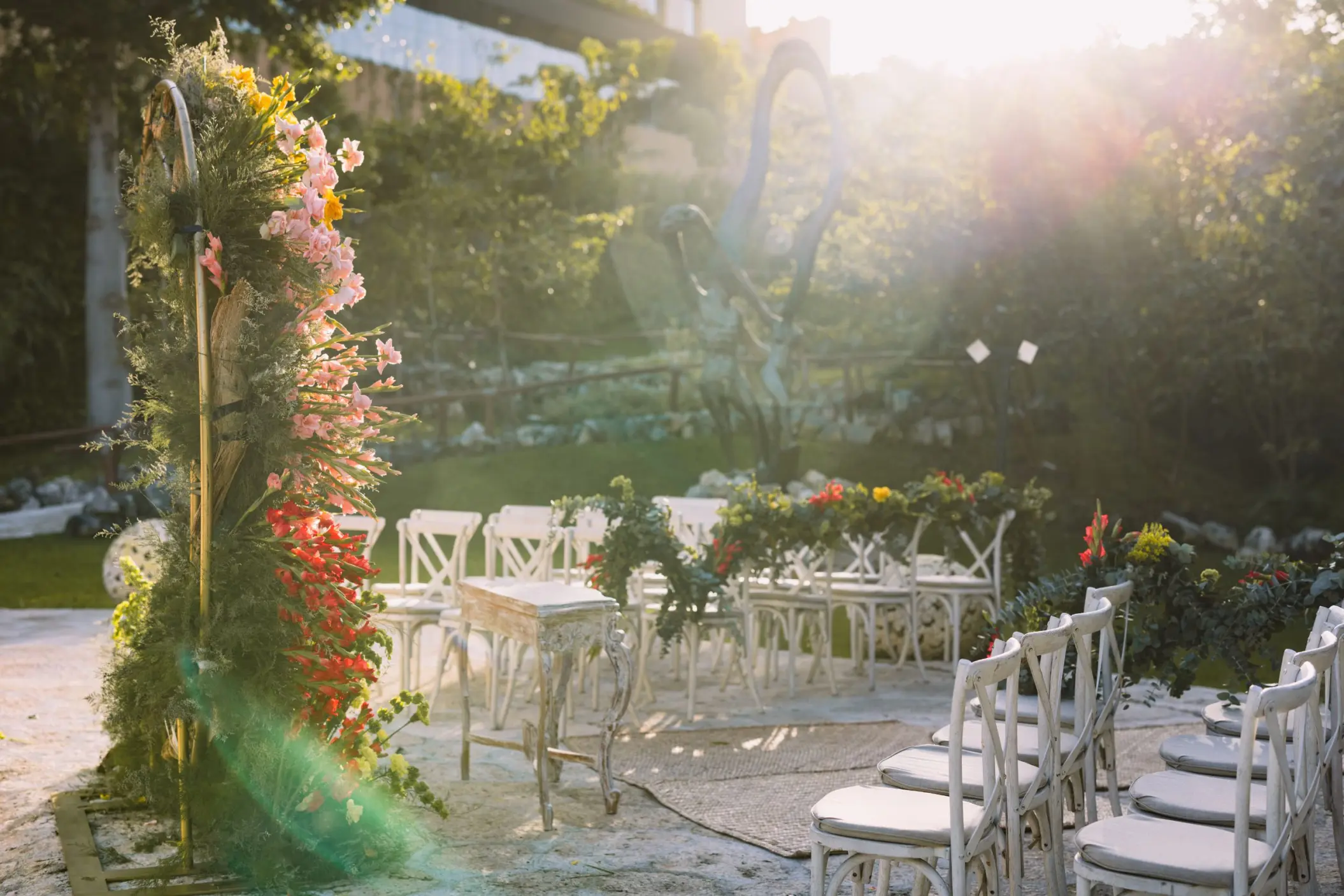 Caracol wedding ceremony setup with white chairs and floral arch at Hotel Xcaret Arte, Riviera Maya