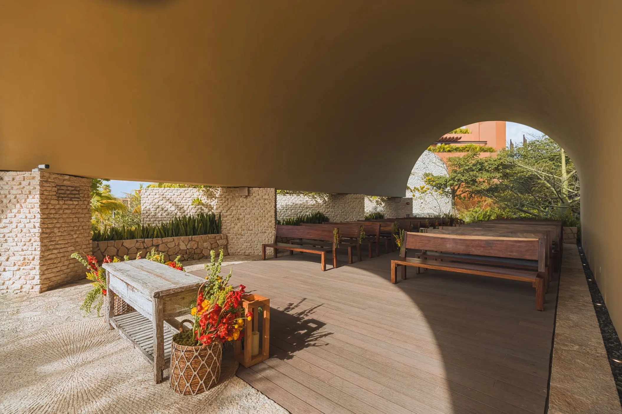 Ecumenical chapel wedding ceremony setup with wooden pews at Hotel Xcaret Arte, Riviera Maya