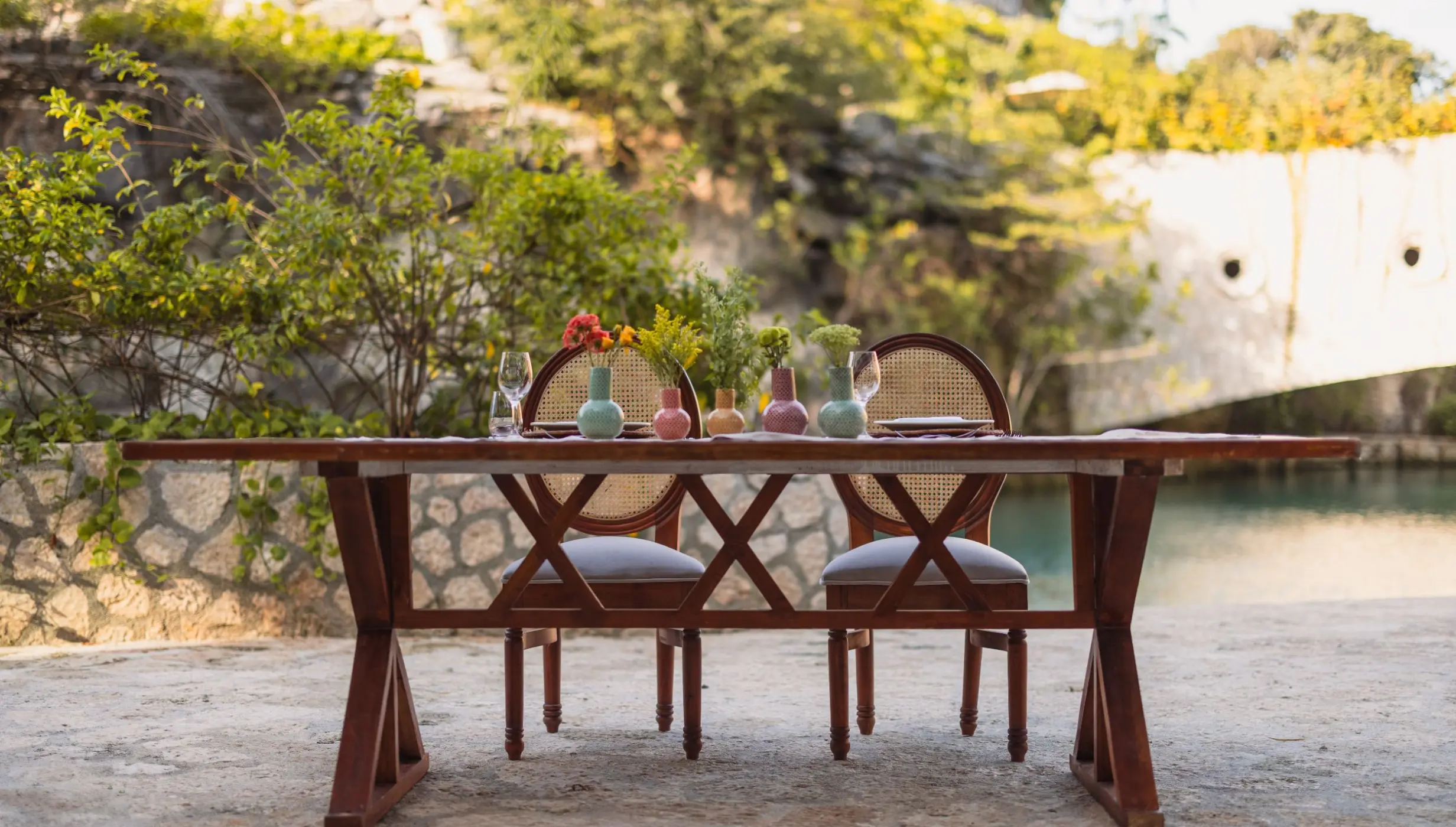 Private dinner table set by a natural lagoon at Hotel Xcaret Arte, Riviera Maya