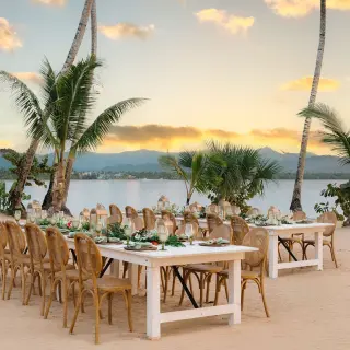Beachfront wedding reception setup with wooden tables at Zemi Miches, Punta Cana