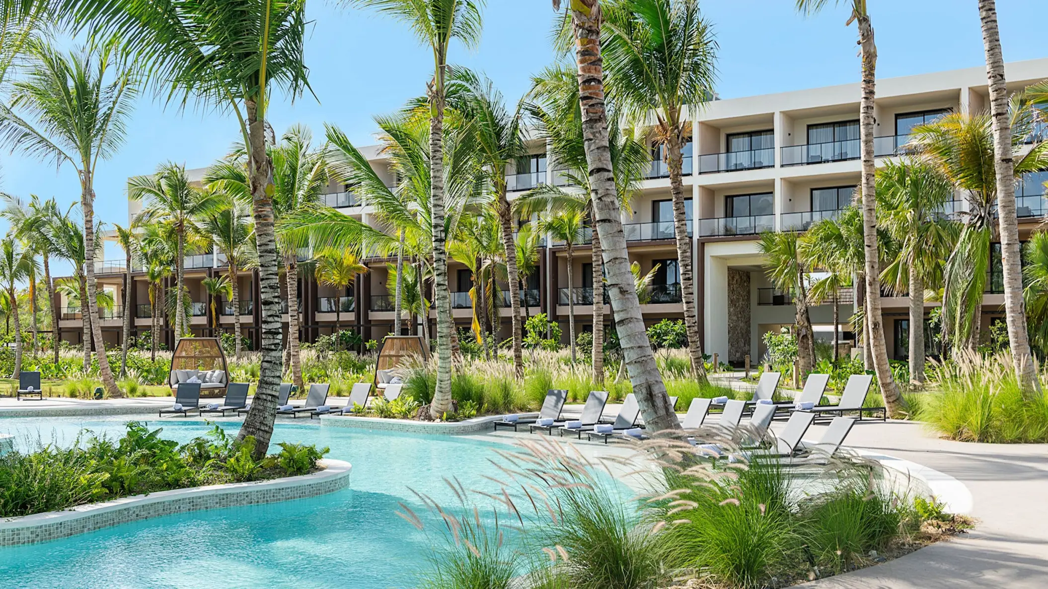Club Azure pool area with lounge chairs and palm trees at Zemi Miches, Punta Cana