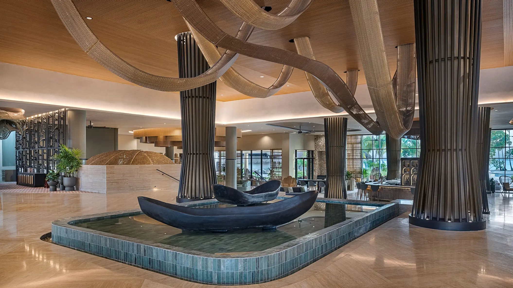 Modern open-air lobby with a central water feature and hanging art at Zemi Miches, Punta Cana