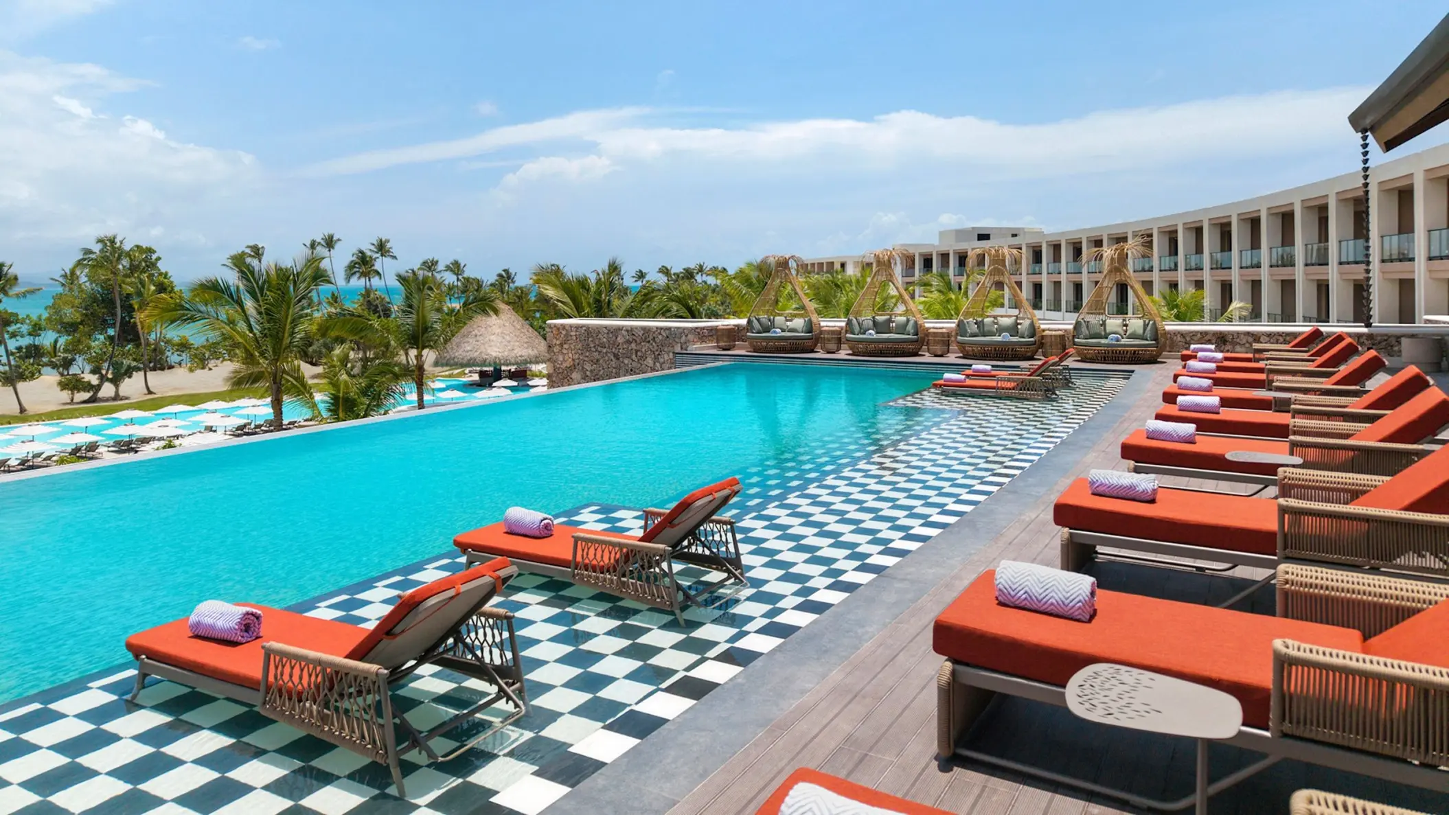 Royal Palm infinity pool with orange loungers at Zemi Miches, Punta Cana