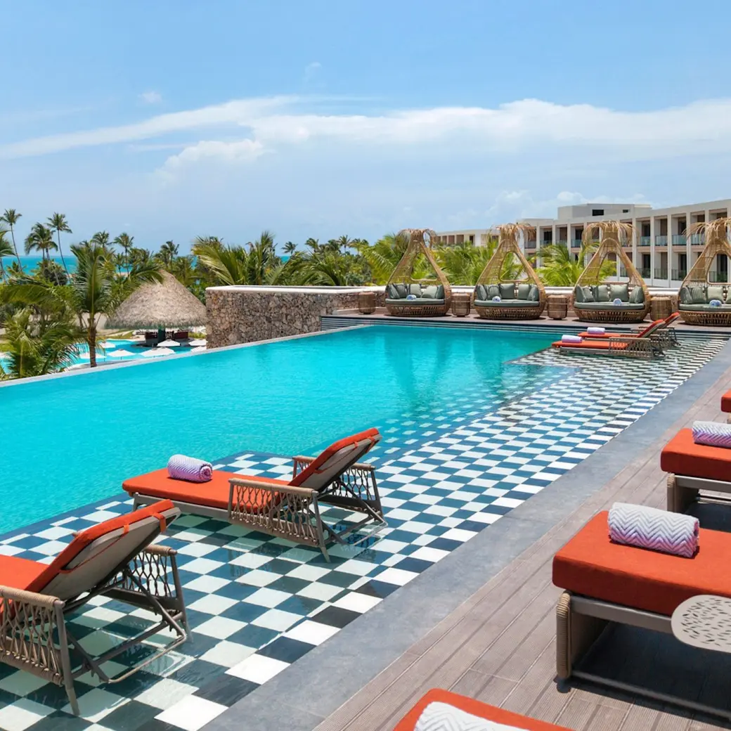 Royal Palm infinity pool with orange loungers at Zemi Miches, Punta Cana