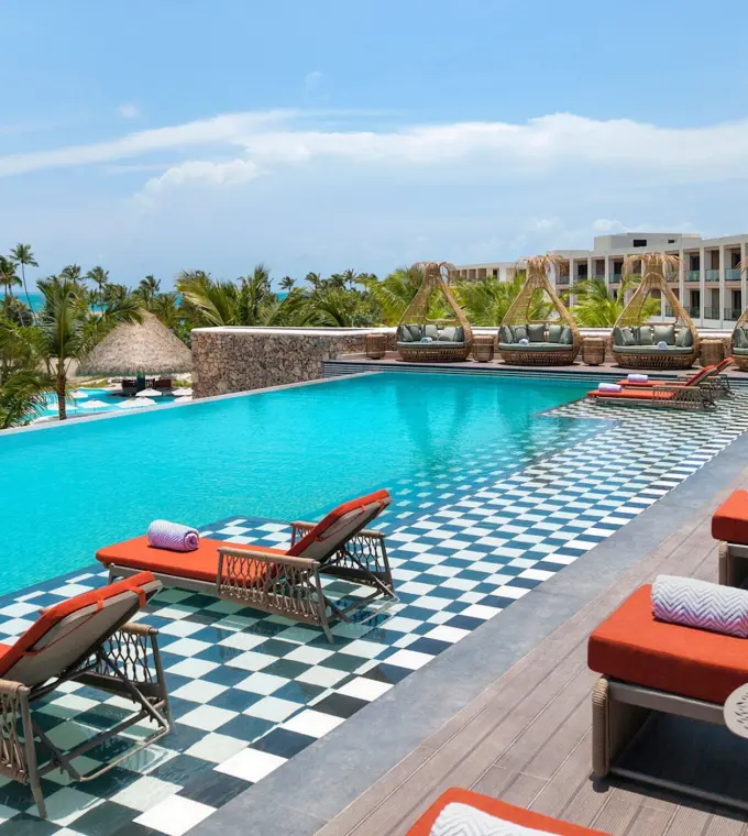 Royal Palm infinity pool with orange loungers at Zemi Miches, Punta Cana