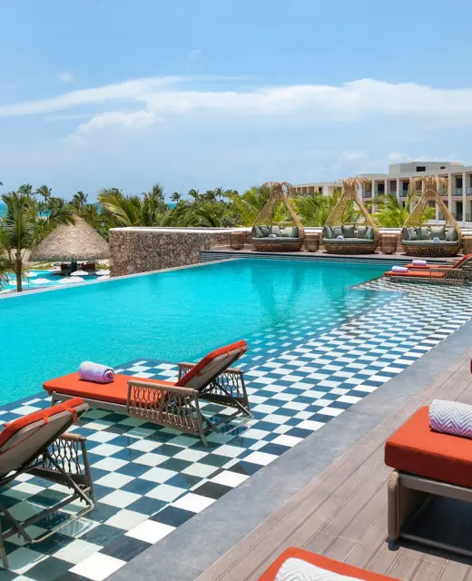 Royal Palm infinity pool with orange loungers at Zemi Miches, Punta Cana