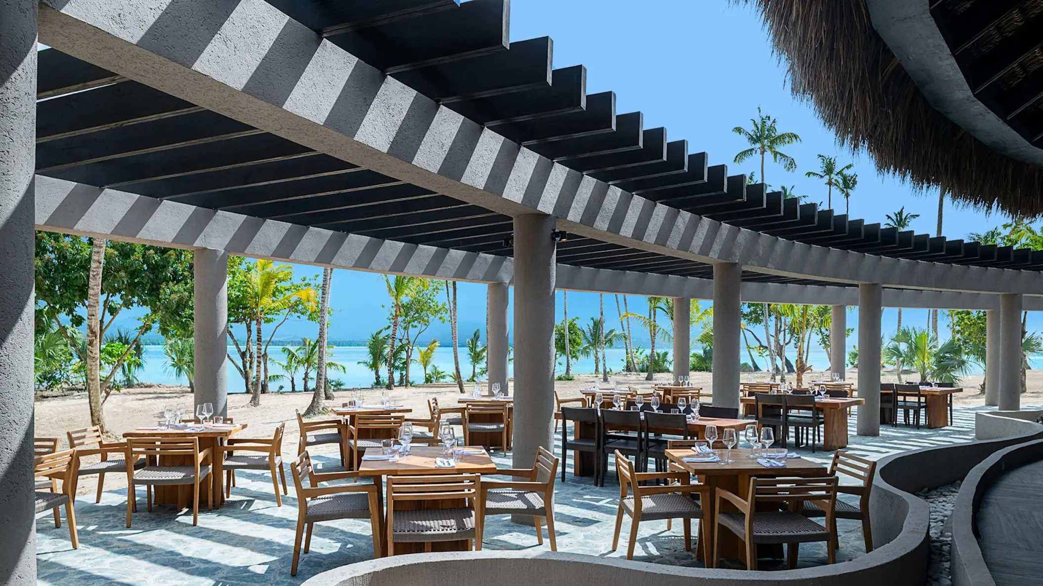 Yuca restaurant terrace with wooden tables under a modern pergola at Zemi Miches, Punta Cana