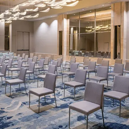 Ballroom setup with grey chairs and blue patterned carpet at Zemi Miches, Punta Cana