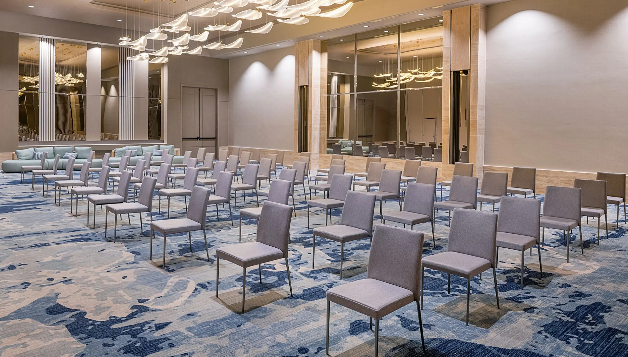 Ballroom setup with grey chairs and blue patterned carpet at Zemi Miches, Punta Cana