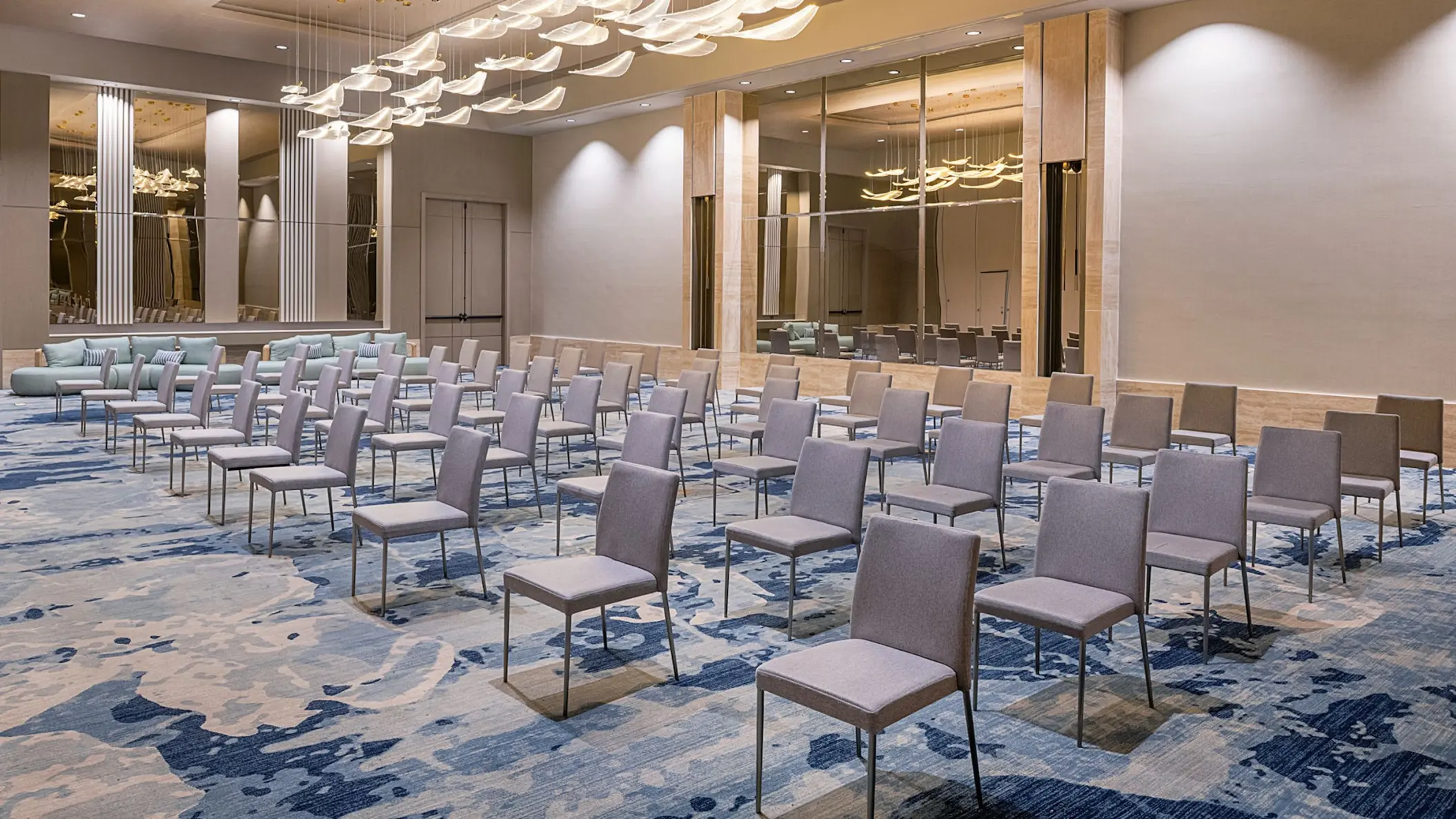 Ballroom setup with grey chairs and blue patterned carpet at Zemi Miches, Punta Cana