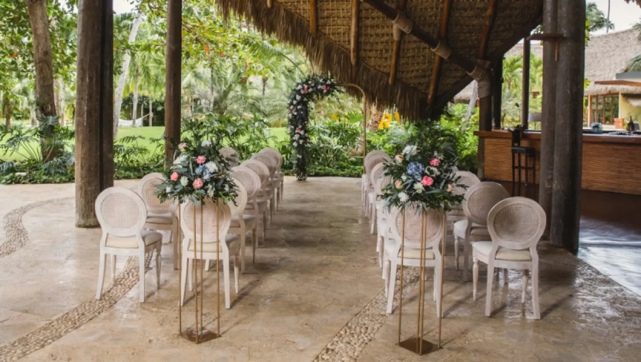 Sheltered wedding ceremony setup with white chairs and floral arrangements at Zoetry Agua Punta Cana